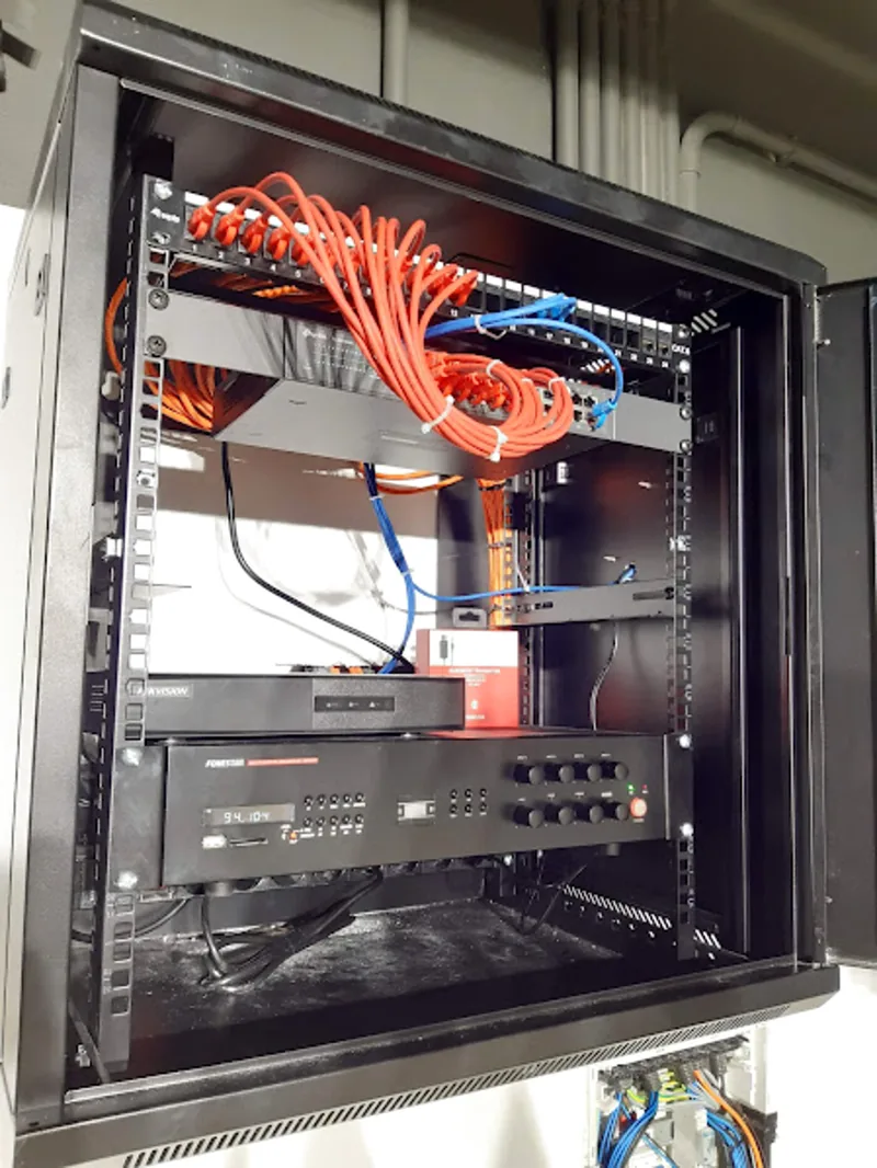Rack profesional con switches gestionables, NVR Hikvision y cableado Cat6 organizado